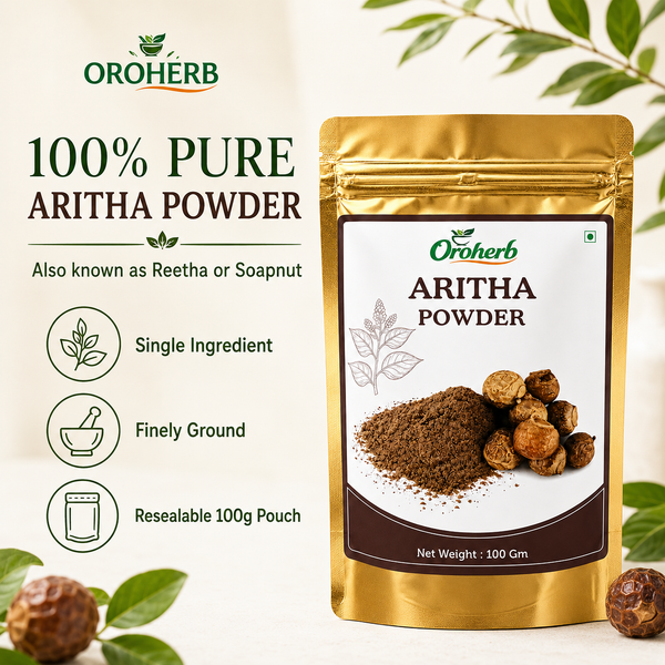 A stand-up pouch of Oroherb 100% Pure Aritha Powder (reetha/soapnut powder) on a light cream background with decorative green leaves and whole aritha nuts. The left side features product benefits, and the right side features the product packaging.